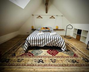 a bedroom with a bed with a rug on the floor at La vie en Grange, la Loire et les châteaux in Dhuizon