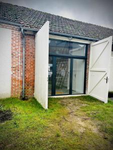 a brick building with two large doors on it at La vie en Grange, la Loire et les châteaux in Dhuizon
