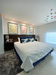 a bedroom with a large bed with blue pillows at Studio Hotel Boutique in San José
