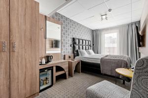 a hotel room with a bed and a television at Best Western Plus Savoy Lulea in Luleå +107 photos