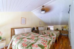 a bedroom with two beds and a ceiling at Aloha Nui Loa in Kahuku