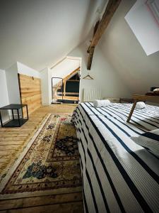 - une chambre avec un lit et un tapis au sol dans l'établissement La vie en Grange, la Loire et les châteaux, à Dhuizon