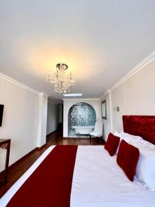 基多的住宿－Dakani Hotel Boutique NEW，卧室配有带红色枕头的大型白色床
