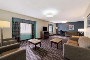 a living room with couches and a couch and a tv at SureStay Plus Hotel by Best Western Elizabeth City in Elizabeth City