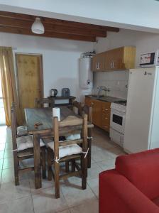 cocina con mesa, sillas y nevera en Alojamientos Rossi en Malargüe