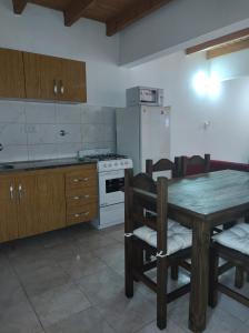 kuchnia ze stołem, krzesłami i kuchenką w obiekcie Alojamientos Rossi w mieście Malargüe