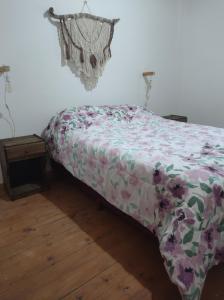 łóżko z kwiatową kołdrą w pokoju w obiekcie Alojamientos Rossi w mieście Malargüe