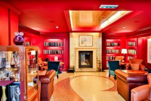 a red room with red walls and chairs and a library at Aria Hotel Prague in Prague