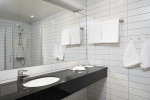 a bathroom with a sink and a mirror at Thon Hotel Sandven in Norheimsund