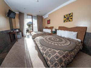 a hotel room with two beds and a television at Dharma Beach in Montañita