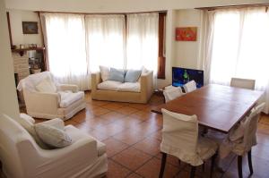 sala de estar con mesa de madera y sillas blancas en Chalet Playa Grande en Mar del Plata