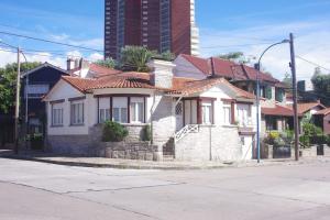 una casa blanca con techos rojos en una calle de la ciudad en Chalet Playa Grande en Mar del Plata