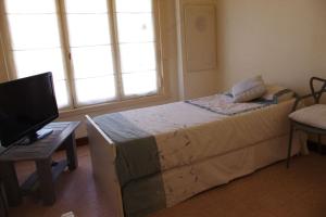 1 dormitorio con 1 cama y escritorio con TV en Chalet Playa Grande en Mar del Plata