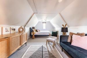een woonkamer met een bank en een bed bij Bressingham Lodge - Norfolk Holiday Properties in Diss