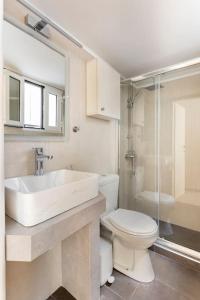 Un baño con lavabo, inodoro y ducha. en Acropolis View, en Atenas