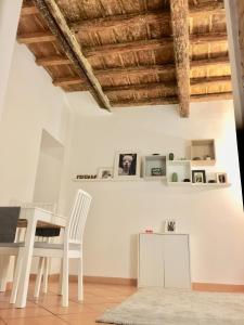 een eetkamer met witte meubels en houten plafonds bij The heart of Trastevere in Rome