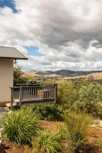 a wooden bench sitting in the middle of a field at WATTLE TREE HILL in Gundagai