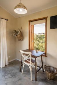 einen Tisch und einen Stuhl in einem Zimmer mit Fenster in der Unterkunft WATTLE TREE HILL in Gundagai