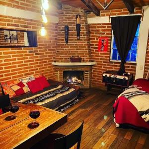 sala de estar con chimenea, cama y mesa en Cabañas las Alazanas, en Mazamitla