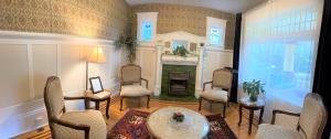 a living room with a fireplace and a table and chairs at Windsor Guest House in Vancouver