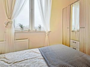 um quarto com uma cama e uma janela em Apartament Kameralny III na Starówce em Gdansk