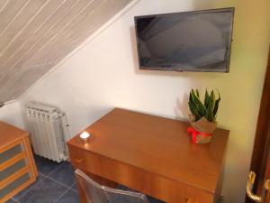 Habitación con mesa y TV en la pared. en Kintsugi Loft en Turín