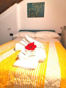 - un lit avec des serviettes et une fleur rouge dans l'établissement Kintsugi Loft, à Turin