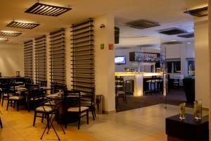 a restaurant with tables and chairs and a bar at HOTEL AEROPUERTO MORELIA in Álvaro Obregón