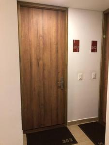 Una gran puerta de madera en una habitación con una puerta Sidx Sidx en EXCLUSIVO APARTAMENTO BOGOTÁ, en Bogotá