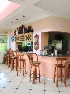 un restaurante con bar con sillas de madera y barra en Nuestro Castillo, Playa San Blas, La Libertad, El Salvador en La Libertad