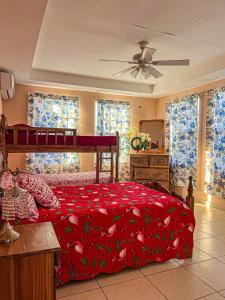 1 dormitorio con 1 cama con colcha roja en Nuestro Castillo, Playa San Blas, La Libertad, El Salvador en La Libertad