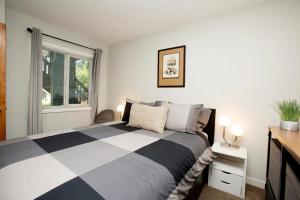 a bedroom with a black and white bed and a window at Gondola Haus - Free parking in Whistler