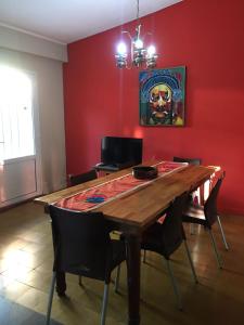 comedor con mesa de madera y pared roja en CASA - CHALET VILLA DEL DIQUE en Villa del Dique