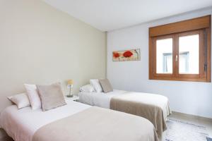 2 bedden in een witte kamer met een raam bij Céntrico y con Vistas Santa Cruz, Vacation Home in Santa Cruz de Tenerife