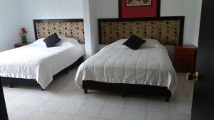 1 dormitorio con 2 camas en Hotel Palmas Teotihuacán, en San Juan Teotihuacán