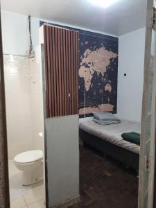 a small room with a bed and a toilet at Kitnet BH in Belo Horizonte