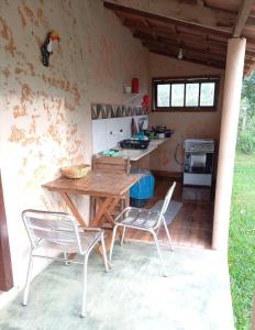 a kitchen with a wooden table and two chairs at Chalés Ocaso in Sao Jorge