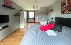 a bedroom with a bed with red pillows on it at 5 Bedroom Awesome Home In Bray-ls-mareuil in Bray-lès-Mareuil