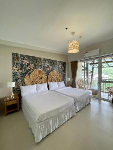 um quarto com uma grande cama branca e uma grande janela em 3BD/3BA Penthouse - Tropical Oasis in Pico de Loro em Patungan