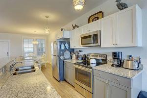 a kitchen with white cabinets and a blue refrigerator at TSC203 Fisher Oceanfront Elevator in Kill Devil Hills