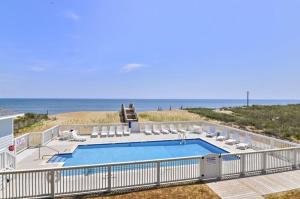a swimming pool with chairs and the beach at TSC203 Fisher Oceanfront Elevator in Kill Devil Hills