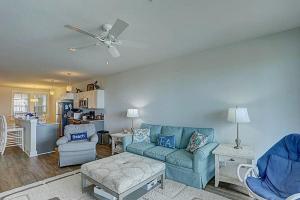 a living room with a blue couch and chairs at TSC203 Fisher Oceanfront Elevator in Kill Devil Hills