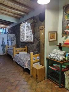 a bedroom with two beds and a stone wall at LOS CHAÑARES CASAS DE CAMPO in Rama Caída