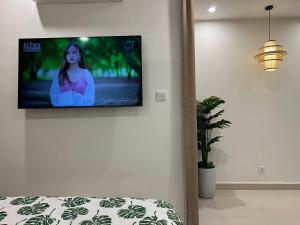 TV de pantalla plana colgada en la pared en Vinhome Grand Park Homestay House en Gò Công