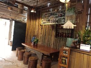 un restaurante con mesa de madera y taburetes en Tribal Village Homestay & Trekking, en Banlung