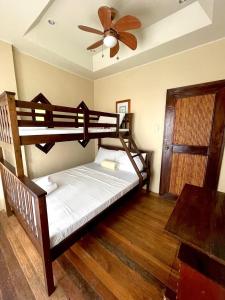 a bedroom with two bunk beds and a ceiling fan at Casita Ysabel in Mabini