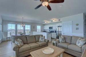 a living room with a couch and a ceiling fan at TSC404 Seaclusion Oceanfront Elevator in Kill Devil Hills