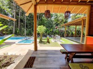 un patio con una mesa y una piscina en Casa com quintal arborizado e lazer em Trancoso, en Porto Seguro