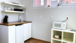 una pequeña cocina con fregadero y microondas en Iturriaga Ostatua Self check in, en Bilbao