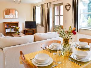 a living room with a table and a couch at Lily Broad Cottage in Burgh Saint Margaret